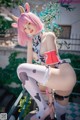 A woman with pink hair wearing a cow costume.