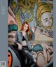 A woman posing in front of a graffiti covered wall.