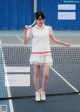 A woman holding a tennis racquet on a tennis court.