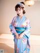 A woman in a blue and purple kimono posing for a picture.