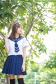 A woman in a school uniform posing for a picture.