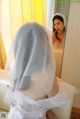 A woman in a wedding dress looking at herself in the mirror.