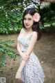 A woman in a floral dress posing for a picture.