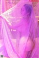 A naked woman is standing under a veil.