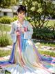 A woman in a colorful dress is posing for a picture.